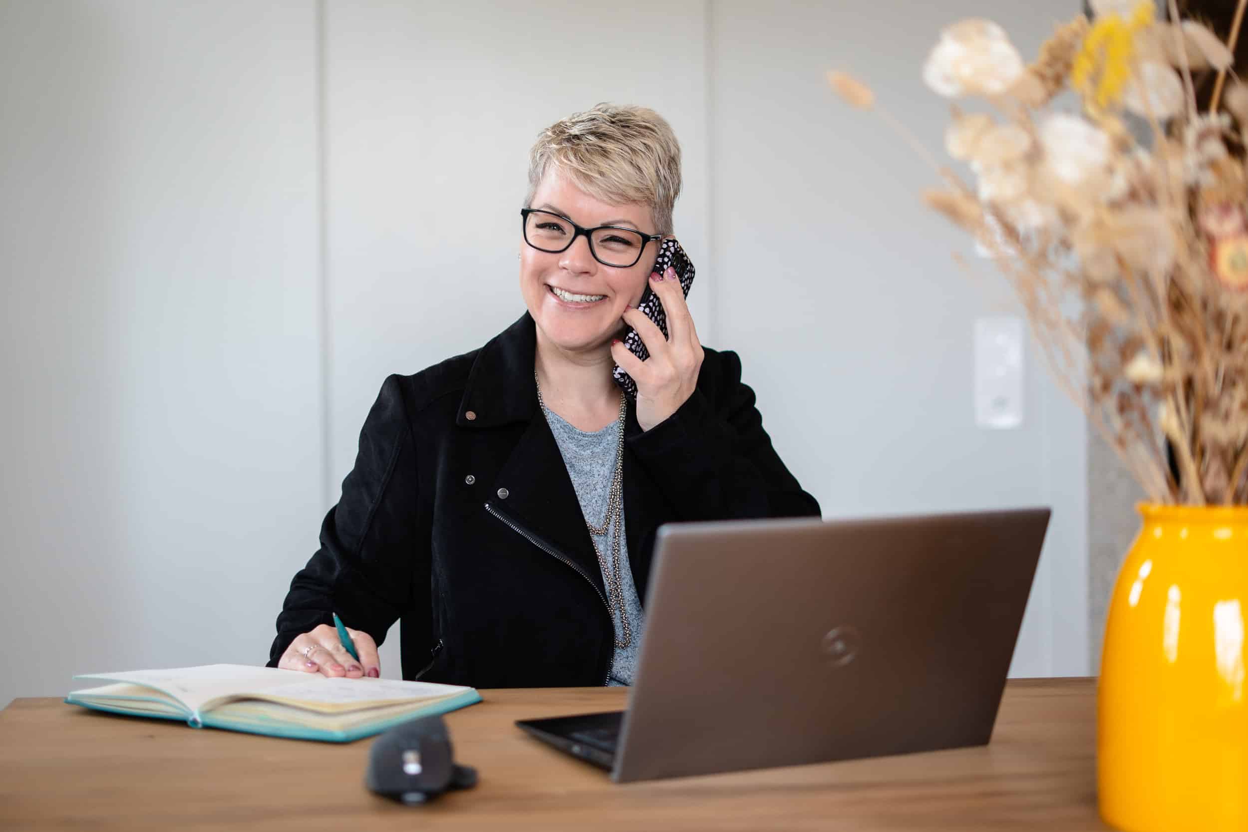 Virtuelle-Assistentin-im-Business-Alltag-bei-der-Arbeit-mit-Telefon-und-Laptop